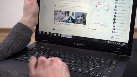 在Facebook上浏览巴黎的照片-男人使用笔记本电脑计划旅行