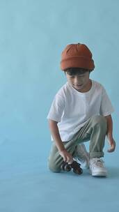 一个小男孩在玩玩具轮子竖屏