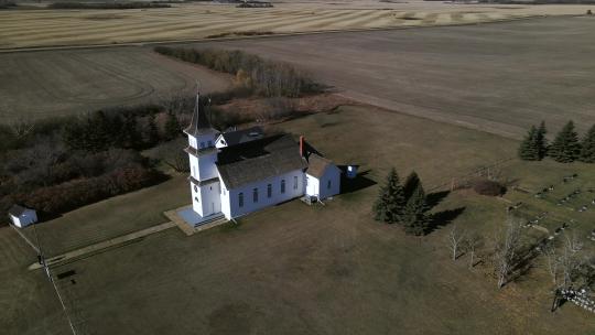 无人机接近坐落在北美草原景观中的美丽古老遗产教堂