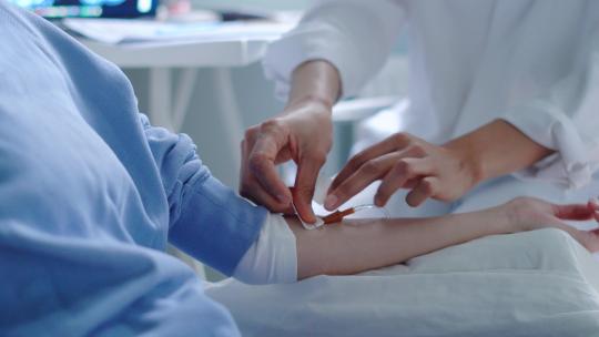 医生的手在病人的左臂上固定静脉注射视频素材模板下载
