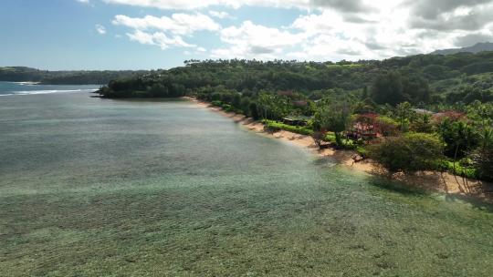高空航拍飞越夏威夷考艾岛阿尼尼海滩。浅水清澈的水域和郁郁葱葱的岛屿视频素材模板下载