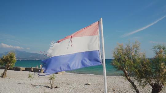 2319_被撕裂的红、白、蓝国旗在沙滩上飘扬