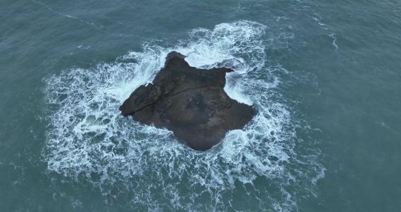 蓝色大海中礁石俯拍海水拍打岩石浪花泡沫