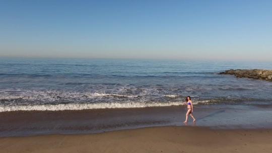 女人走在沙滩上