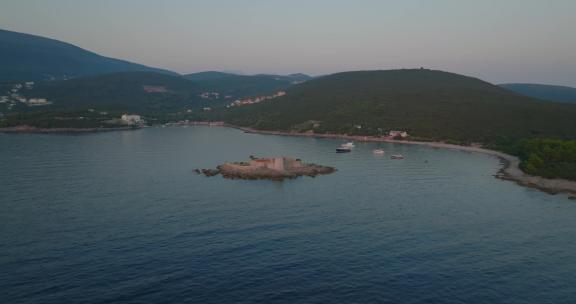 日落时奥托西克·戈斯帕岛的轨道拍摄，背景是游艇和船只