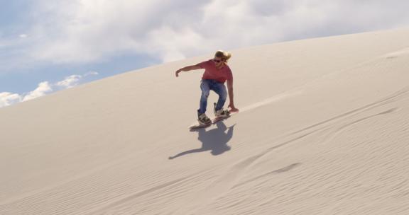 沙漠上滑沙的男人