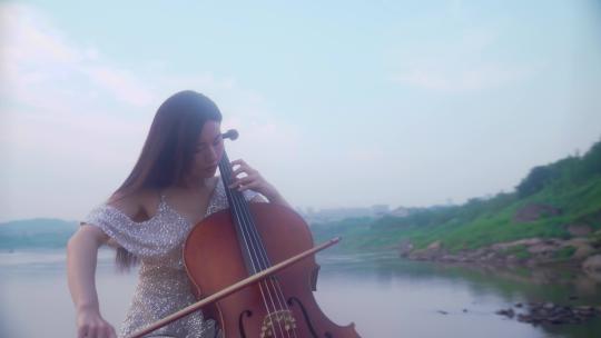 美女江边拉大提琴