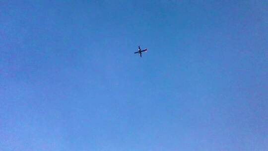 仰拍一架飞机在蓝天下飞行
