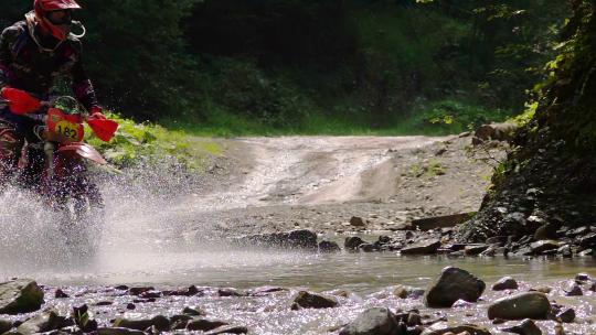 摩托车骑手穿越山区河流视频素材模板下载