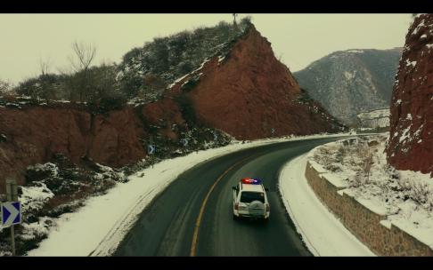 航拍冬季下雪天交警在国道上巡逻