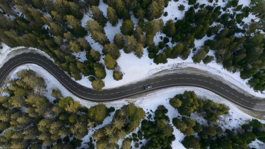 航拍森林公路上行驶的汽车森林雪景