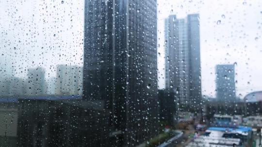 雨天玻璃上的水珠窗外高楼雨景雨滴鸭脚木叶