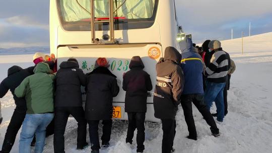 西藏纳木措乘客推动陷在雪地里的客车视频素材模板下载