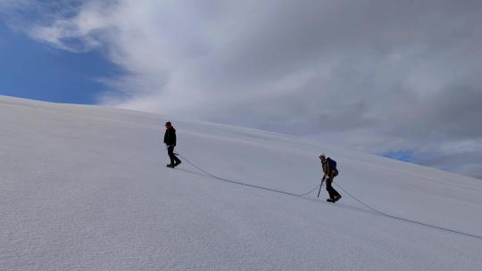 攀登沙鲁里山脉尼登贡嘎雪山冰川上的登山者