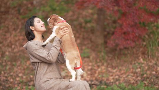 女人把她的狗抱在腿上亲吻