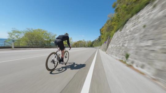 FPV航拍公路骑行的男子骑自行车快速行驶