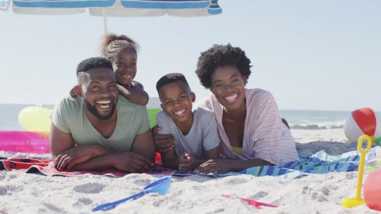 黑人家庭躺在海滩上大笑的视频