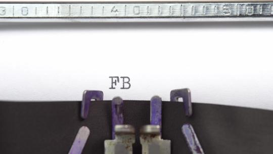 联邦调查局档案短语特写正在打字，并以旧老式打字机上的一张纸为中心