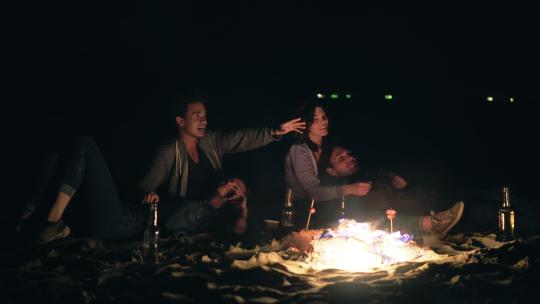 两对可爱的情侣相拥坐在篝火旁看星星