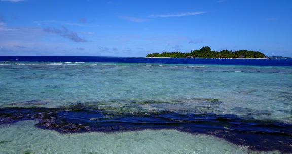 白色天堂海滩和蓝色大海背景的日间俯瞰岛屿景观