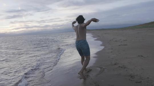 男舞者在海滩上舞动视频素材模板下载