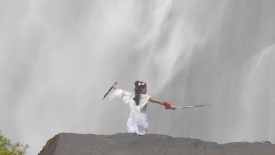 震撼瀑布山中前飞流直下古代汉服美少女舞剑视频素材模板下载