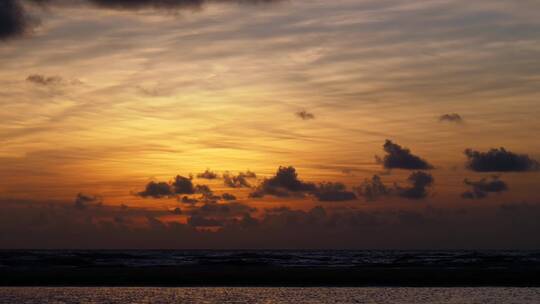 从海滩上看日落时分的橙黄天空  延时