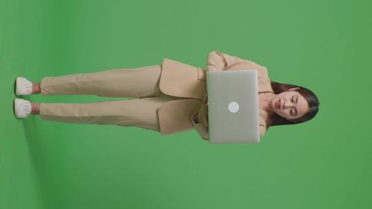 女商人在绿屏上使用笔记本电脑