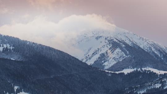冬季景观中黄昏时的云在山上移动