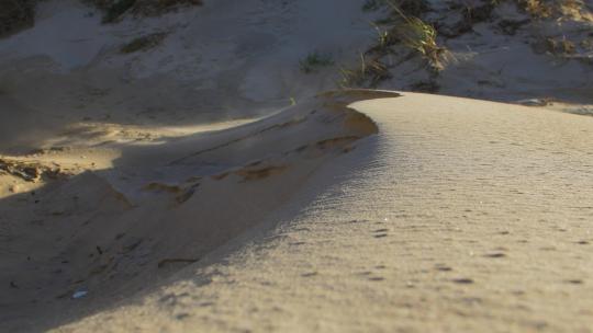 海边沙丘的沙尘在空气中流动，由于高