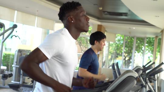 男人白天在健身房的跑步机上跑步视频素材模板下载