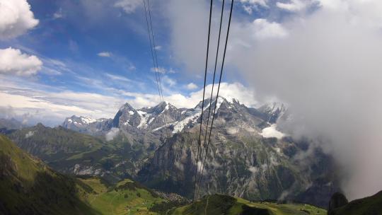 瑞士落基山脉中的缆车攀登和高空云层穿越，下面的山谷，gopro景观
