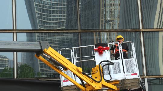 城市高楼起重机上戴安全帽劳动工作的工人