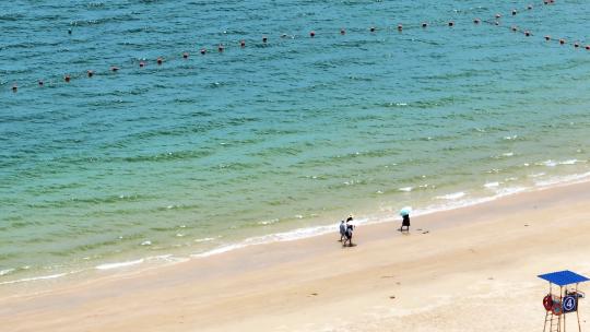 航拍蓝色大海沙滩海浪海岸线上行走的人
