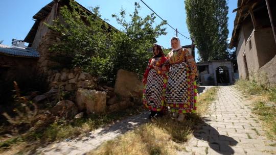 穿着土耳其传统服装的女孩在村子里散步