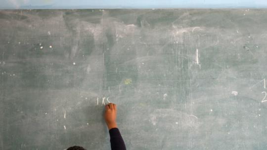 女学生在教室的黑板上写字4k高清在线视频素材下载