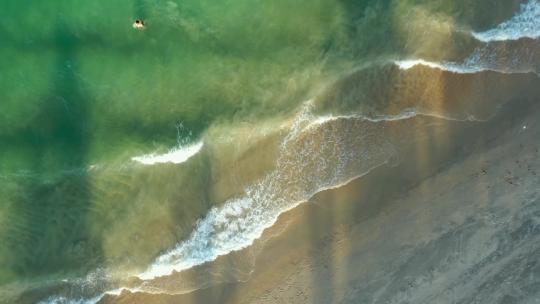 芽庄海滩的无人机视图，绿松石海滩、海浪、沙滩和棕榈的阴影——芽庄市，