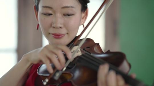 一个红衣女人在窗前拉小提琴的特写 (1)
