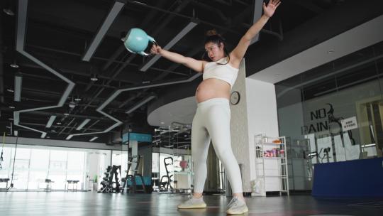 现代女性怀孕的妇女在健身房锻炼身体