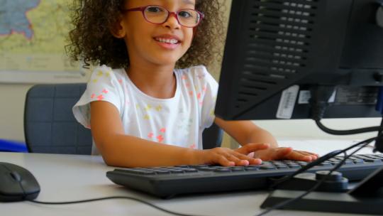 女孩在教室使用台式电脑