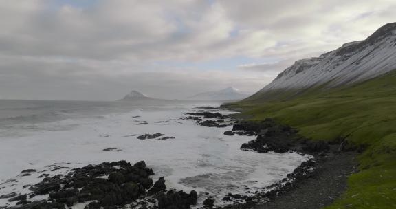 冰岛海岸格陵兰海岩石海岸上空的空中运动，绿草如茵