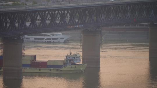 武汉市长江大桥下清晨日出通过的运输船