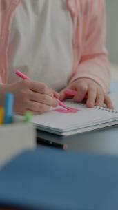 幼儿在笔记本上使用彩色铅笔的垂直视频特写