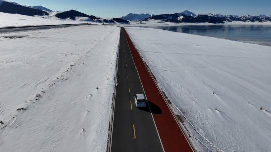 新疆雪中公路汽车行驶向远方雪山