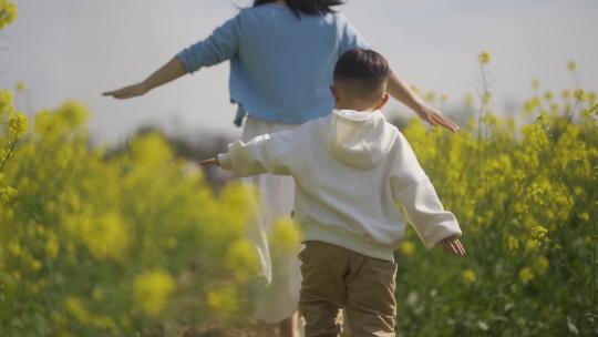 年轻妈妈陪伴孩子健康成长春游踏青户外玩耍