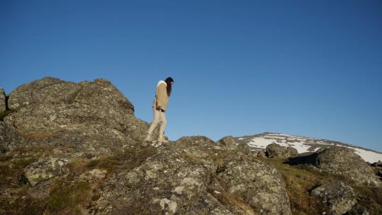 山峰背景下一个女孩走在悬崖边视频素材模板下载