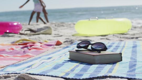 躺在海滩上的太阳镜、书籍、毛巾和海滩设备的视频
