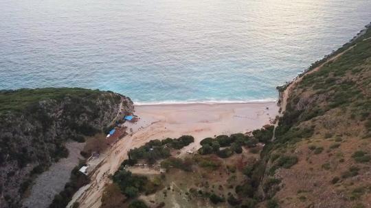 吉普海滩日落时分，沿着阿尔巴尼亚里维埃拉，有海滩小屋，海浪拍打着海滩