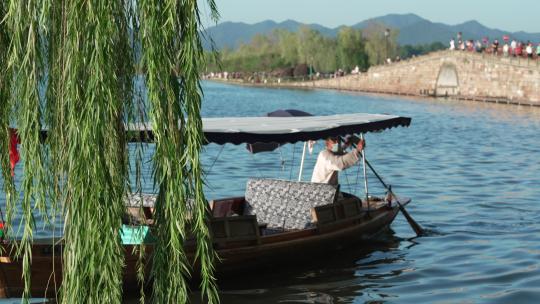 杭州西湖断桥边小船从杨柳前划过视频素材模板下载