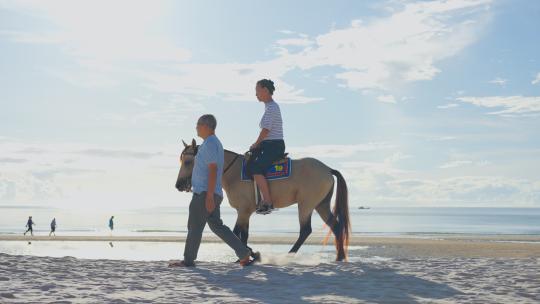 老年夫妇一起在沙滩上骑马